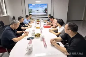 Business meeting around a conference table with a factory photograph on the screen